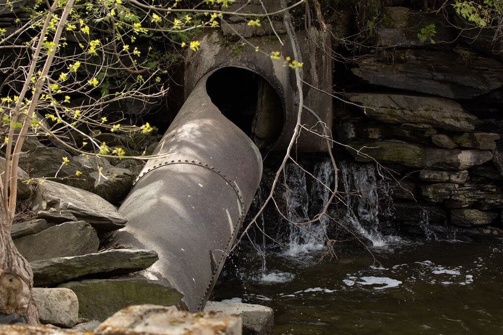 La conduite forcée en tôle rivetée, descendue dans le lit de la rivière